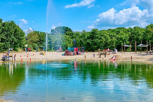 Playa de arena con juegos infantiles y estanque de baño en el camping CAPFUN Heino en Heino.