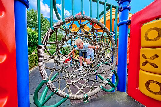 Niño en túnel de cuerdas en parque infantil del camping CAPFUN Heino.