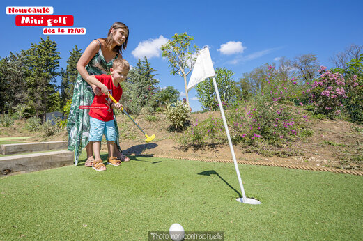 Minigolf: mujer y niño en el camping CAPFUN Huttes en Saint-Denis d'Oléron (17).