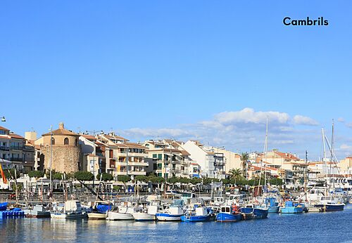 Puerto de Cambrils con barcos y edificios coloridos, lugar para visitar.