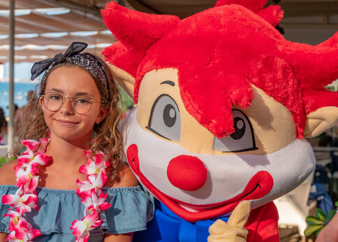 Mascota del camping y niña sonriente en el camping CAPFUN Serra de Prades.